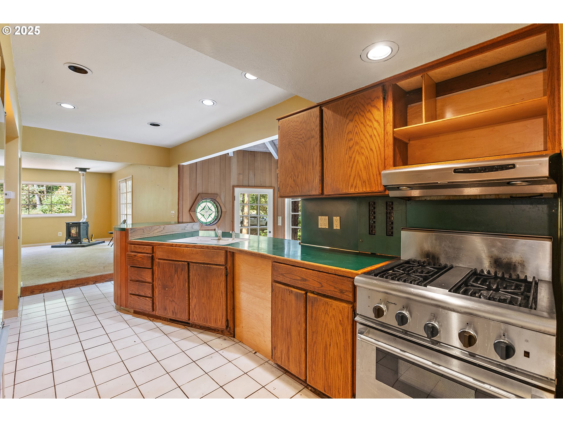 6131 Northwest Thompson Road Portland, OR 97210 - Photo 12 of 48 a kitchen with stainless steel appliances granite countertop a stove a sink and a microwave