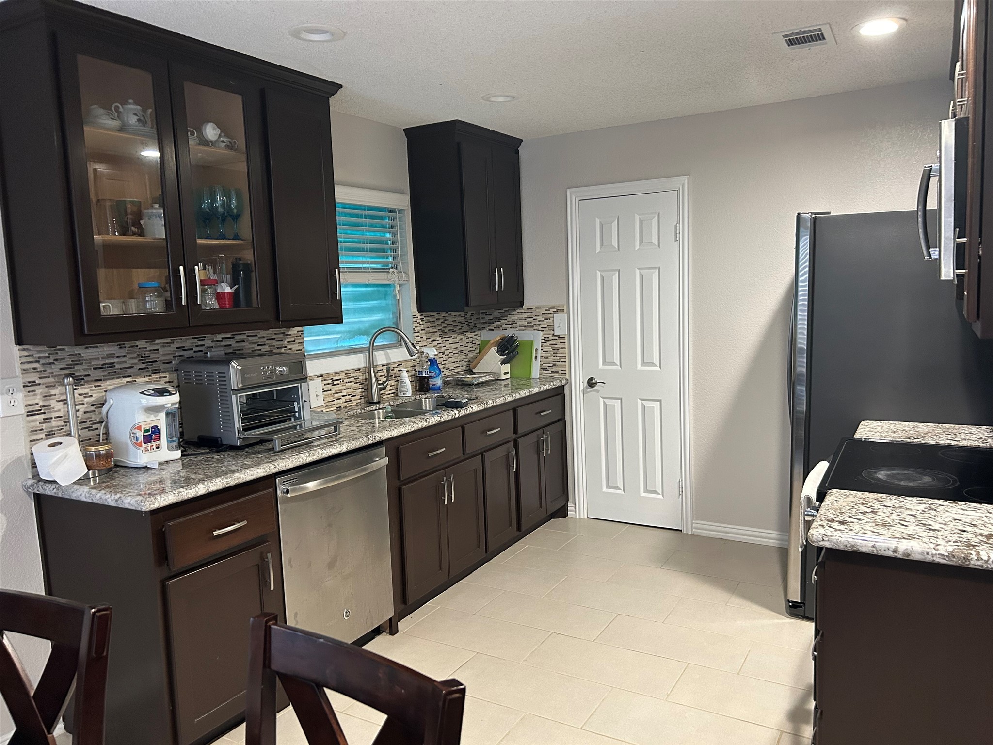 306 Isles End Road Tiki Island, TX 77554 - Photo 13 of 25 a kitchen with stainless steel appliances a sink stove and refrigerator