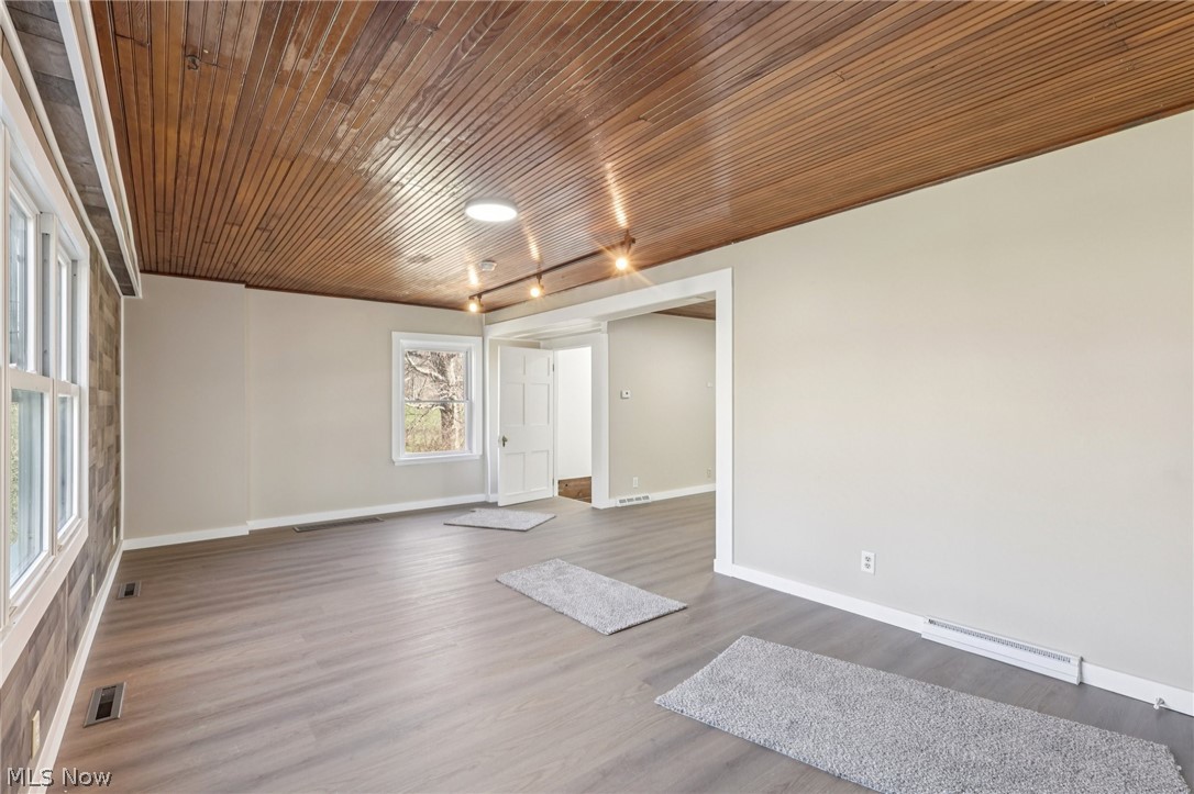 4200 Hattrick Road Rootstown, OH 44272 - Photo 5 of 42 Unfurnished room with dark wood-type flooring, a baseboard heating unit, and wooden ceiling