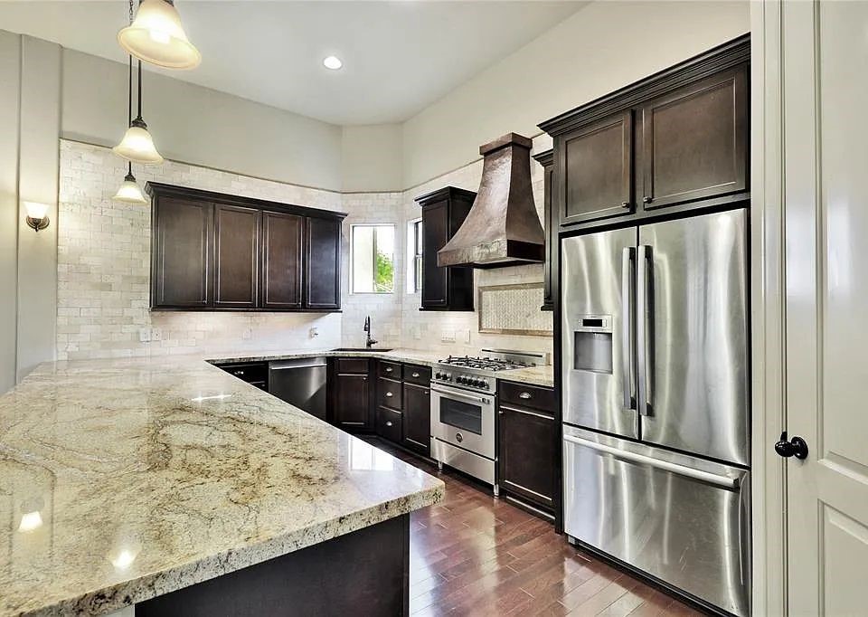 910 Snover Street, Unit A Houston, TX 77007 - Photo 5 of 26 a kitchen with stainless steel appliances granite countertop a refrigerator a stove and a sink with wooden floor