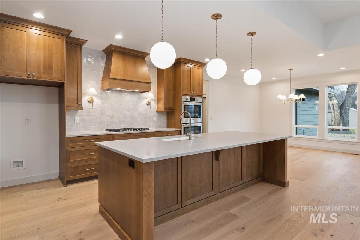 3300 North 39th Street Boise, ID 83703 - Photo 2 of 49 Kitchen featuring wood finish cabinets, light wood-style floors, backsplash, and stainless steel appliances