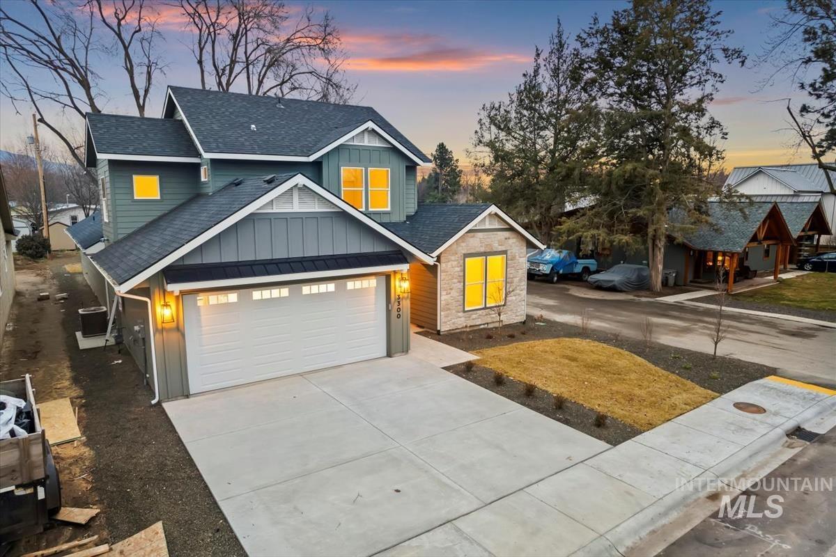 3300 North 39th Street Boise, ID 83703 - Photo 42 of 49 Craftsman-style house featuring board and batten siding, roof with shingles, driveway, and stone siding