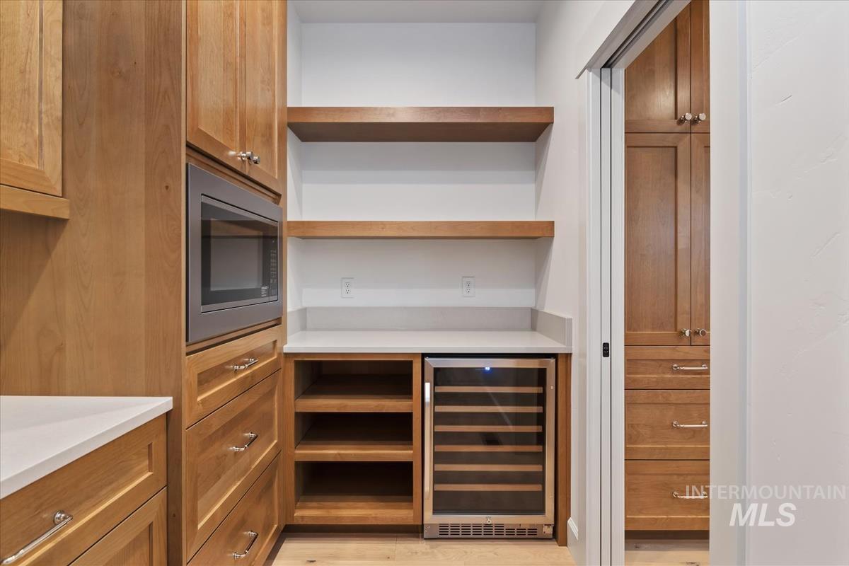 3300 North 39th Street Boise, ID 83703 - Photo 4 of 49 Bar featuring wood finish cabinets, wine cooler, stainless steel microwave, and open shelves