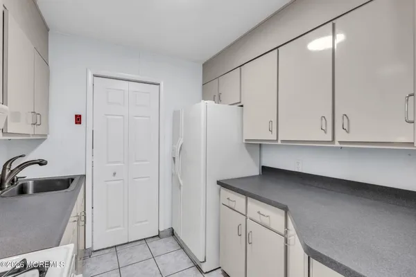 a kitchen with white cabinets and refrigerator