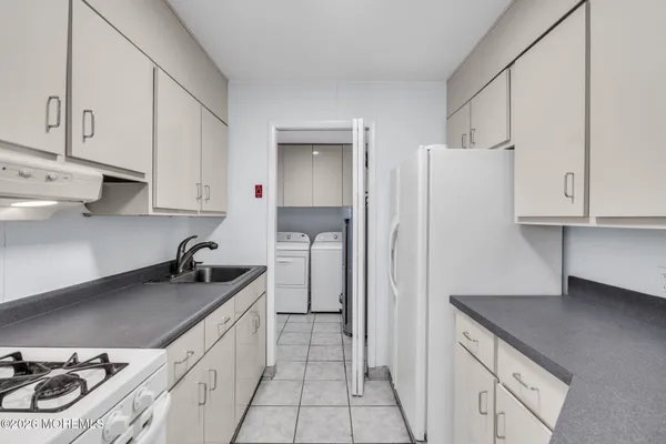 a kitchen with granite countertop a sink a stove and cabinets