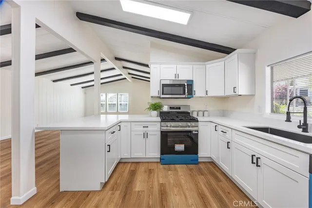 a kitchen with granite countertop a sink appliances cabinets and counter space