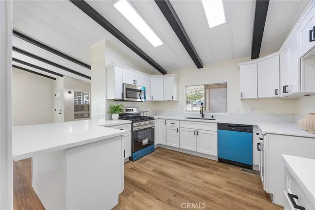 a kitchen with granite countertop cabinets stainless steel appliances a sink and a window