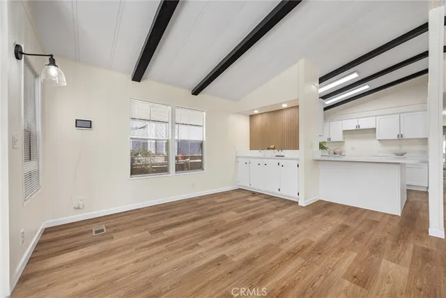 a view of a kitchen with wooden floor and windows