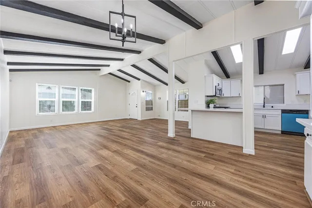 a view of empty room with wooden floor and window
