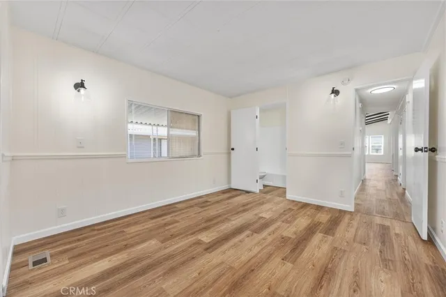 a view of empty room with wooden floor and windows