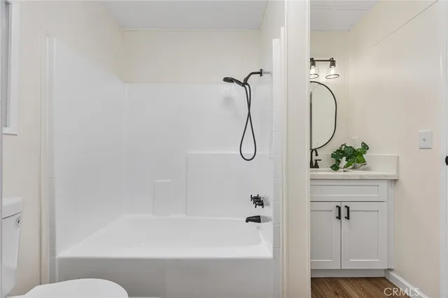 a bathroom with a granite countertop bathtub shower and toilet