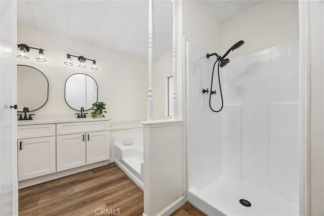 a bathroom with a granite countertop sink a mirror and a shower