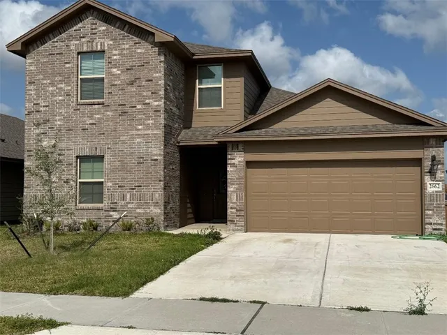a front view of a house with a yard and garage