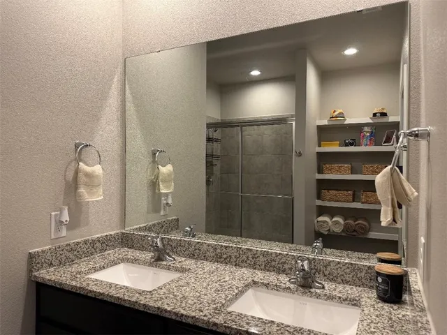 a bathroom with a granite countertop sink and a mirror