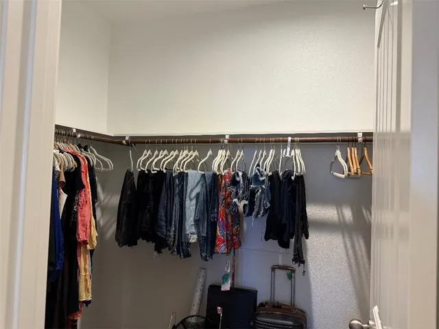 a view of walk in closet with clothes