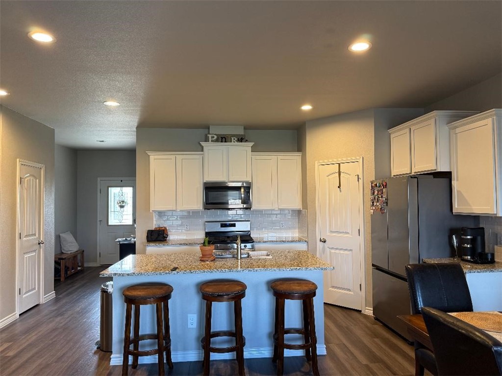 2662 Excelsior Boulevard Corpus Christi, TX 78415 - Photo 2 of 40 a kitchen with stainless steel appliances a refrigerator a stove a sink a dining table and chairs