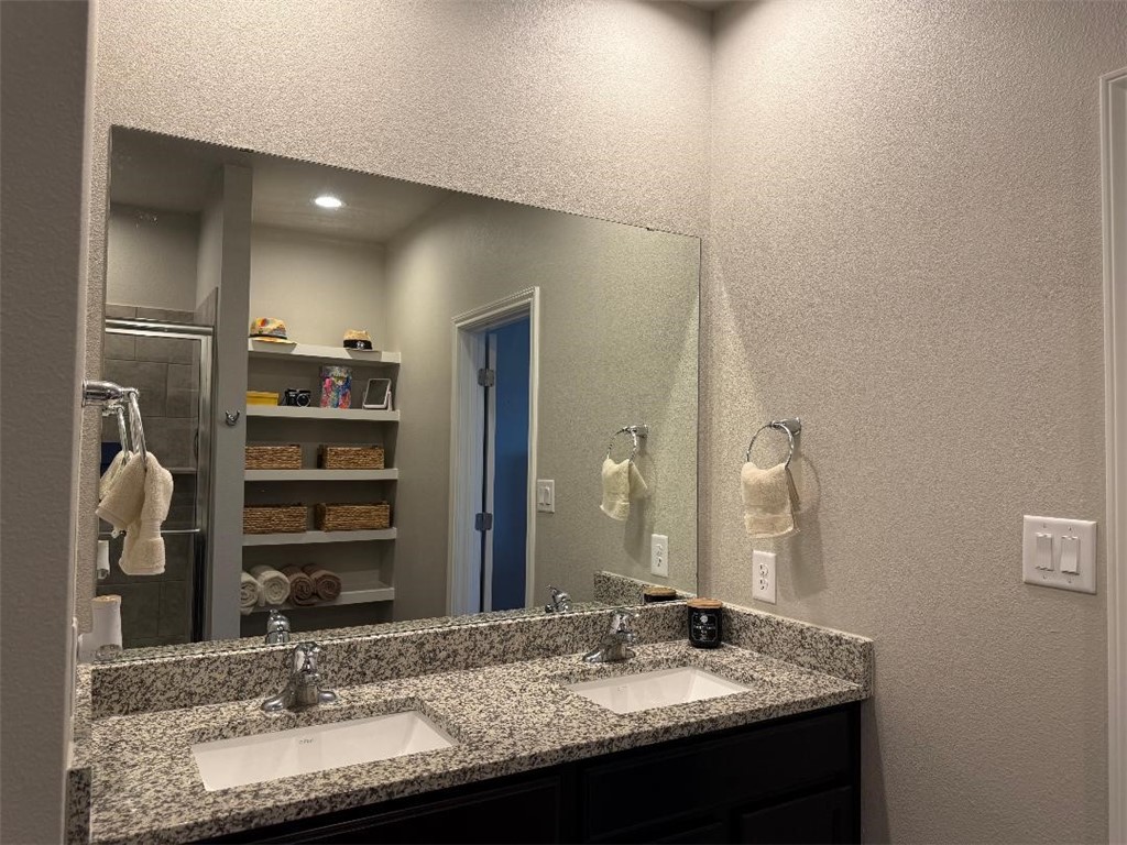 2662 Excelsior Boulevard Corpus Christi, TX 78415 - Photo 21 of 40 a bathroom with a granite countertop sink and a mirror