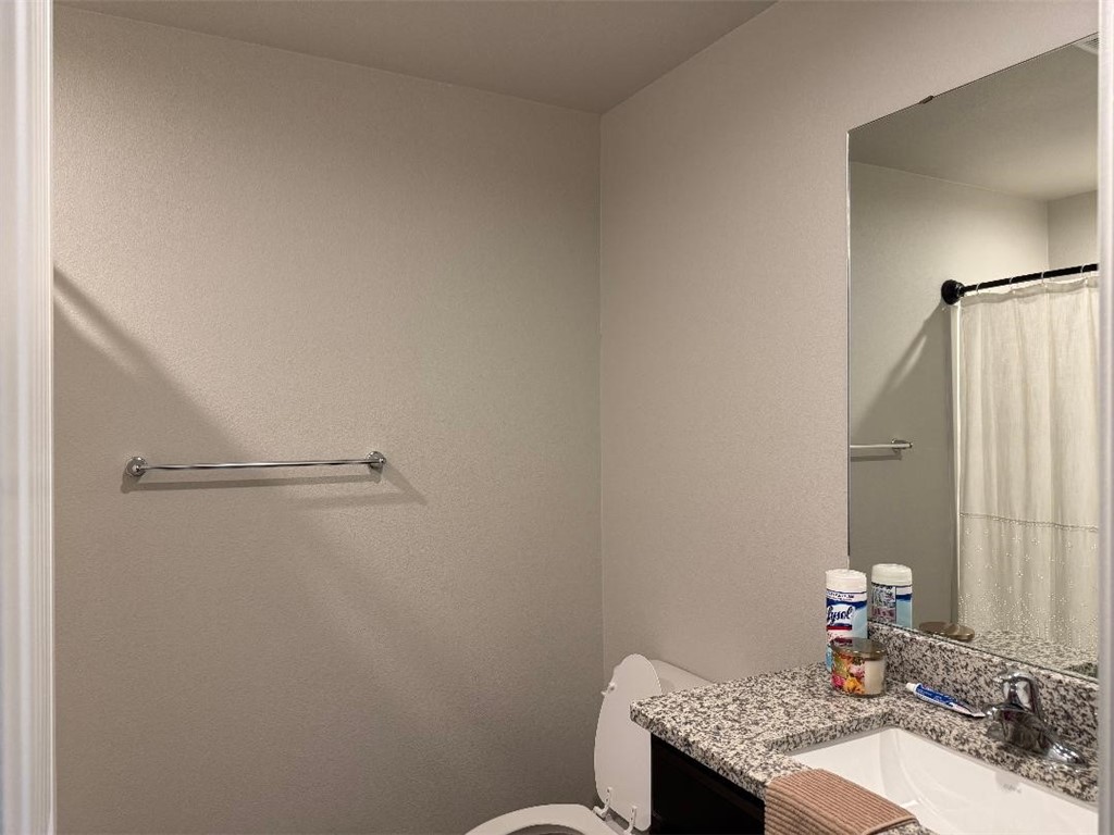 2662 Excelsior Boulevard Corpus Christi, TX 78415 - Photo 29 of 40 a bathroom with a granite countertop sink toilet and a mirror