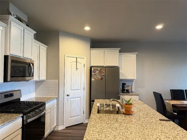 a kitchen with stainless steel appliances granite countertop a refrigerator stove and microwave