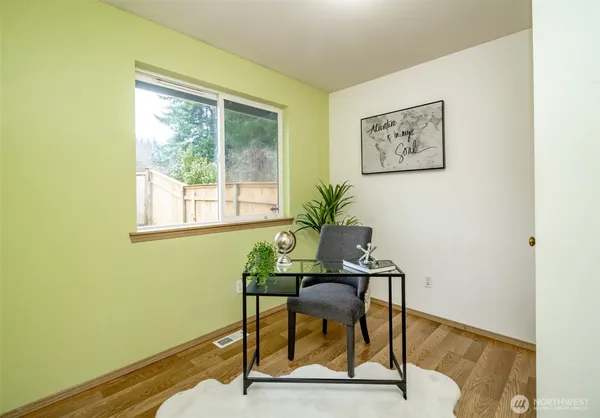 a workspace room with furniture and a potted plant