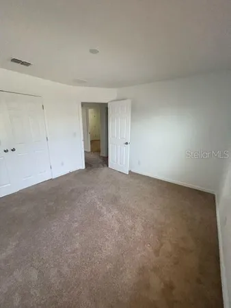 a view of an empty room and closet area