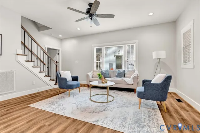 a living room with furniture and a wooden floor