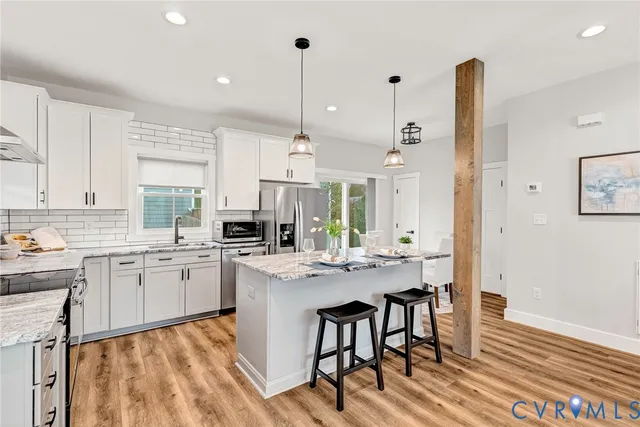 a kitchen with center island white cabinets and stainless steel appliances