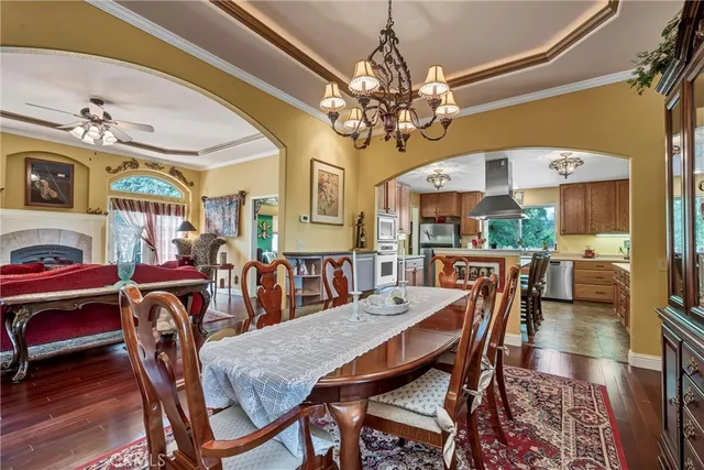 a view of a dining room with furniture a chandelier and wooden floor