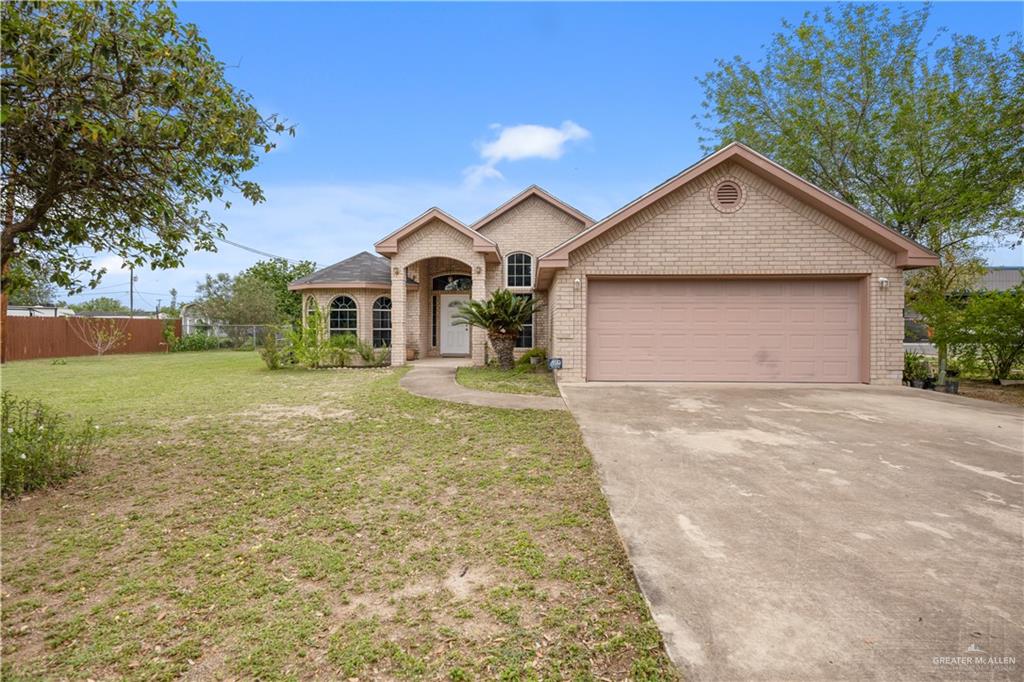 Brick exterior with a prominent arched entry and an attached garage