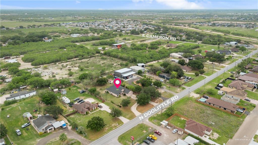 6020 North Doolittle Road Edinburg, TX 78542 - Photo 18 of 23 Aerial perspective showcasing a residential property with a dark roof and light-colored exterior, situated among mature trees