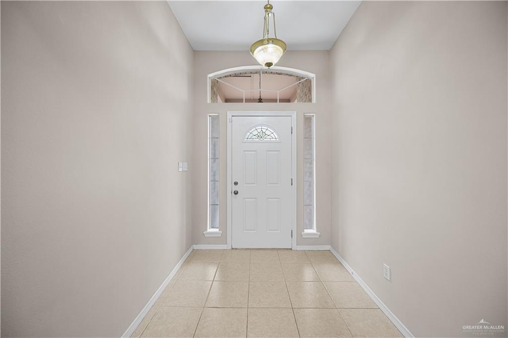 6020 North Doolittle Road Edinburg, TX 78542 - Photo 3 of 23 Foyer featuring tiled flooring, a white paneled entry door with decorative glass, side light windows, and an arched transom window
