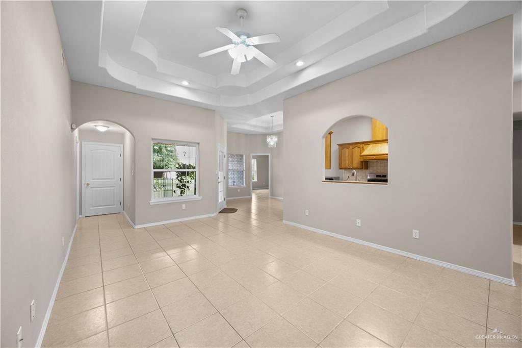 6020 North Doolittle Road Edinburg, TX 78542 - Photo 4 of 23 Spacious interior featuring a decorative tray ceiling with a ceiling fan, recessed lighting, and light-toned tile flooring