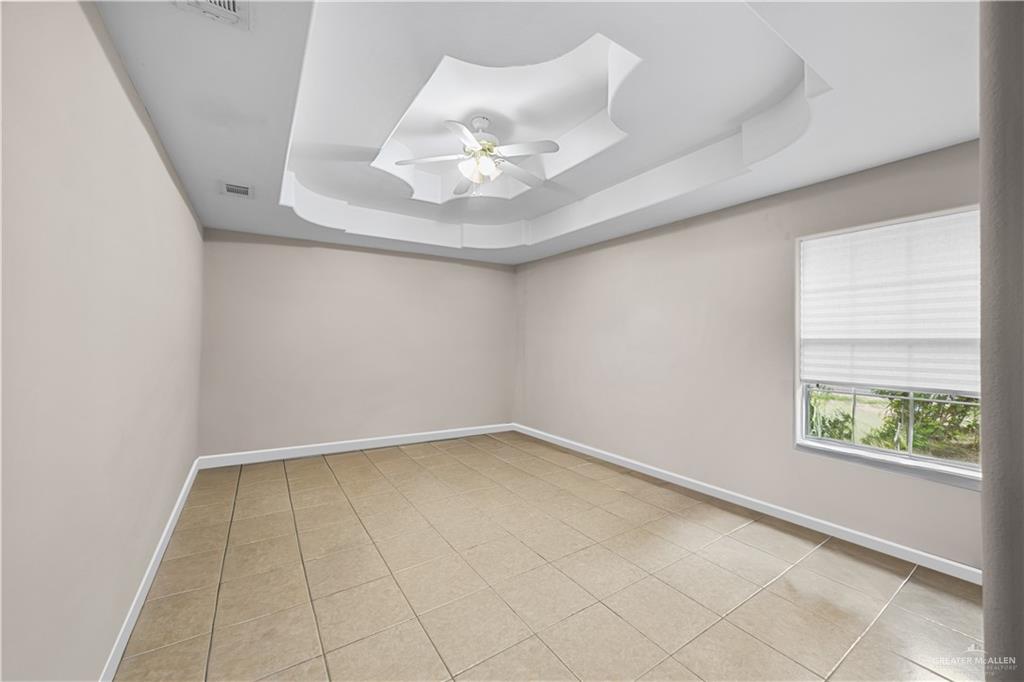 6020 North Doolittle Road Edinburg, TX 78542 - Photo 6 of 23 Tray ceiling with decorative molding, ceiling fan, neutral wall tones, tile flooring, and a window with blinds