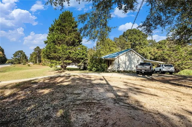 a front view of a house with a yard and trees