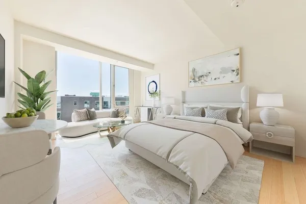 a bedroom with a large bed and a large window
