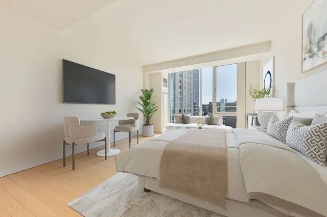 a bedroom with a bed and large window