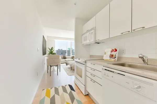 a kitchen with white cabinets and sink