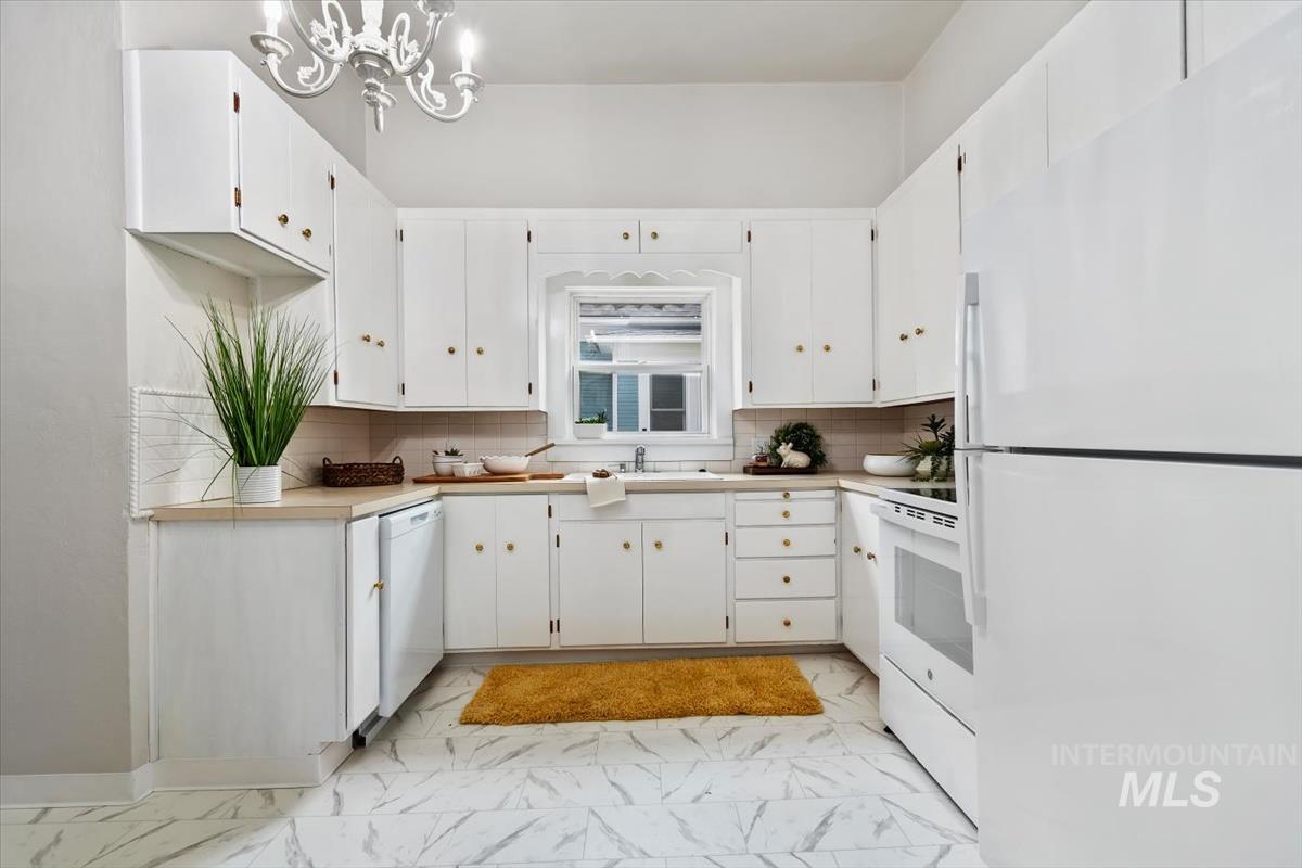 910 North 16th Street Boise, ID 83702 - Photo 17 of 47 U-shaped kitchen featuring white cabinetry, light wood-finish countertops, and a full suite of white appliances