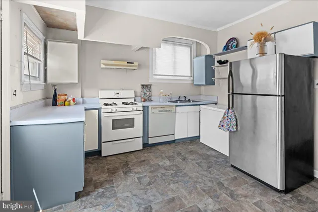 a kitchen with a refrigerator sink stove and cabinets