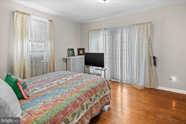 a bedroom with a bed flat screen tv and a window