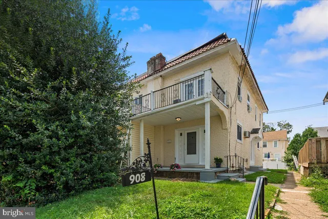 a view of a white house with a yard and plants