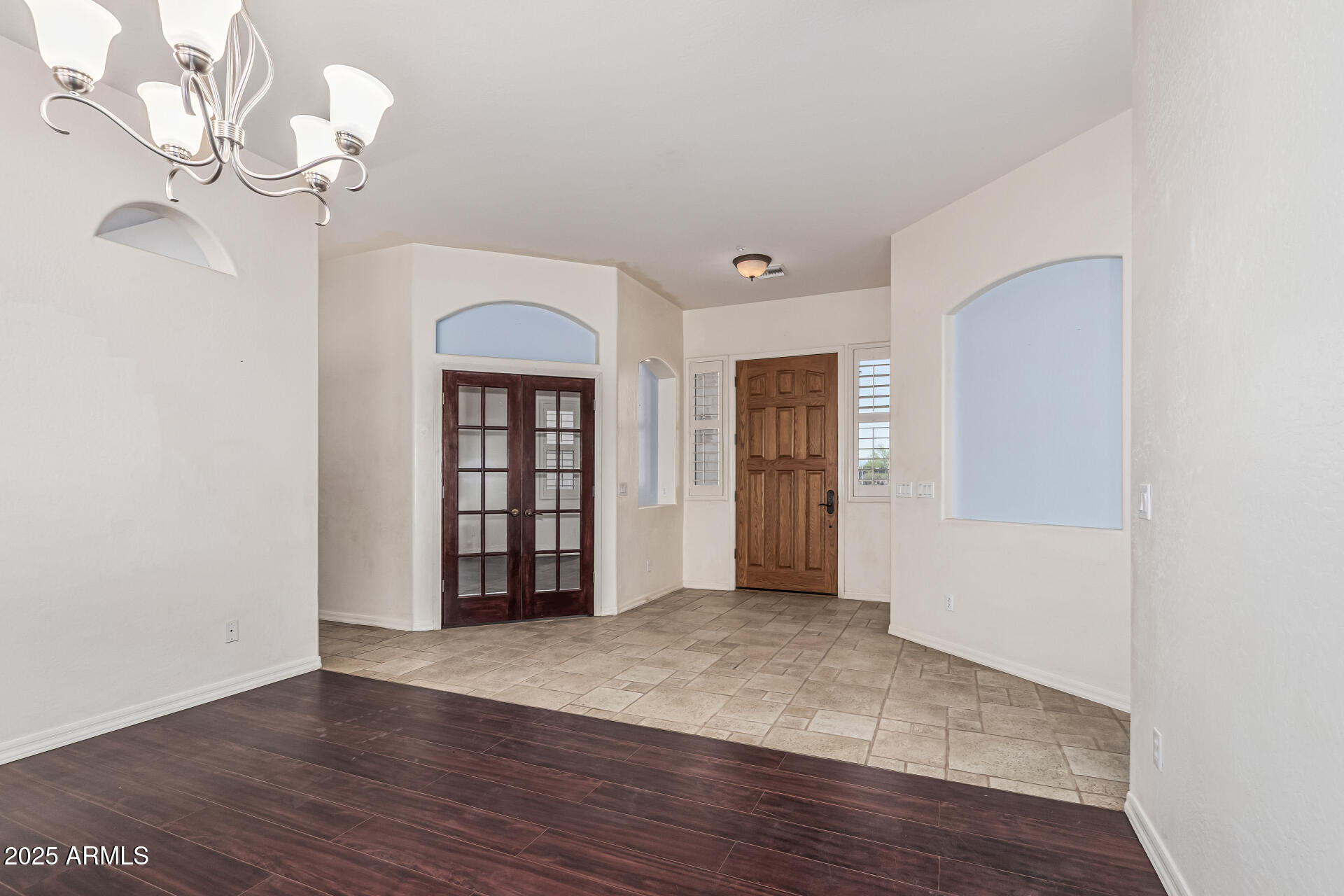 15639 West Peak View Road Surprise, AZ 85387 - Photo 19 of 131 wooden floor in an empty room with a chandelier