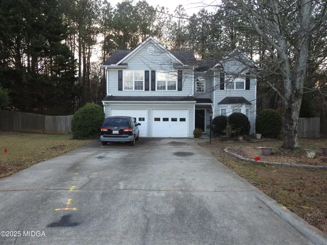 a car parked in front of a white house