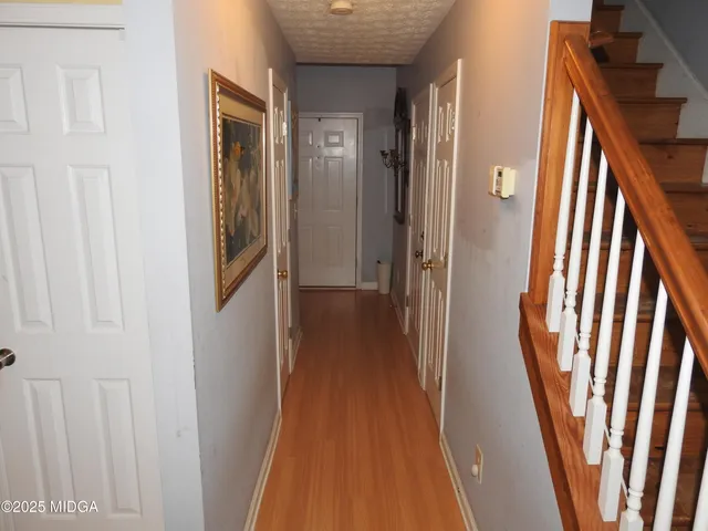 a view of a hallway with wooden floor and staircase