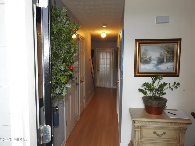 a view of a hallway with wooden floor and a potted plant