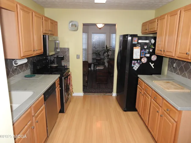 a kitchen with stainless steel appliances a sink stove and refrigerator