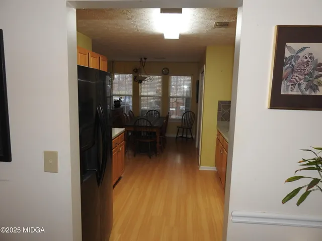 a view of a hallway with wooden floor and furniture