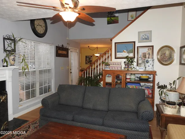 a living room with couches a fireplace and a chandelier