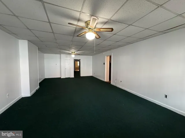 a view of a room with ceiling fan and a projector