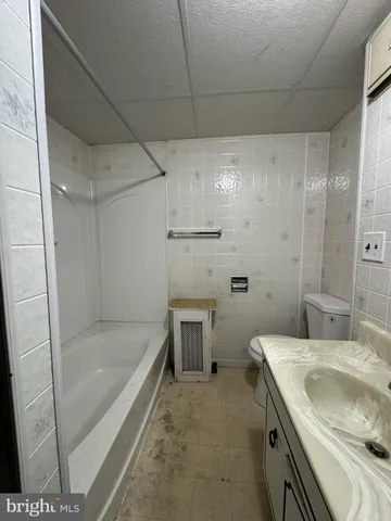 a bathroom with a tub sink toilet and shower